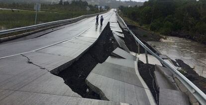 Personas caminan por una carretera destruida en la isla de Chiloe (Chile). 