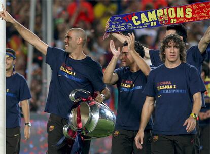 Víctor Valdés, Xavi Hernández y Carles Puyol portan la copa a su llegada a la fiesta con los aficionados en el estadio del Barcelona.