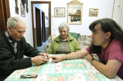 Eugenio y Lola sentados a la mesa con uno de sus hijos invidentes, Eugenio, en su domicilio.