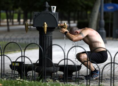 Un hombre se refresca este lunes en una fuente del parque del Retiro, en Madrid.