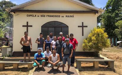 Da Silva (de azul en el centro), rodeado de sus vecinos frente a la capilla de la comunidad.