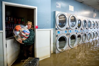 Pamela Cerruti desocupa su lavandería en el poblado de Pajaro, en California (EE UU), mientras las inundaciones rodean las máquinas, el 14 de marzo. "Lo perdimos todo. Eso es medio millón de dólares en equipos", dijo Pamela. 
