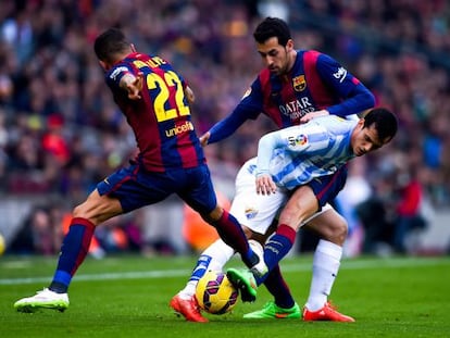 Juanmi protegeix la pilota davant de Piqué i d'Alves.