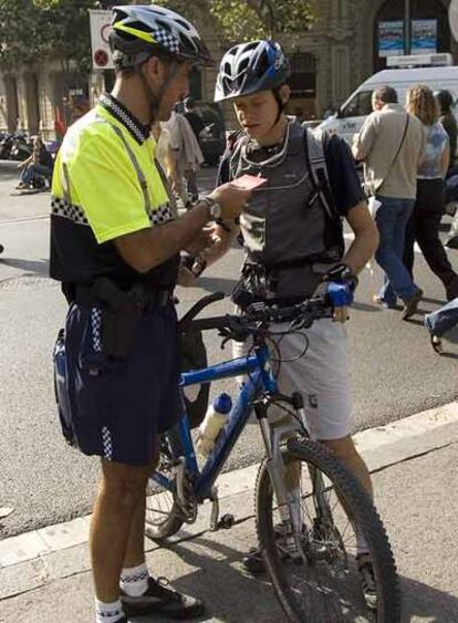 Un guardia urbano informa a un ciclista de la normativa.