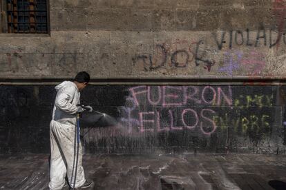 Personal de limpieza del Gobierno local borra con agua a presión las pintas realizadas durante la manifestación del 8-M.