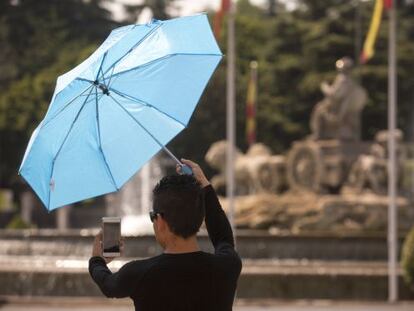 Una turista en Madrid se protege del sol con un paraguas