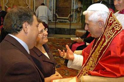 Benedicto XVI presenta ayer a una pareja sin identificar la edición del catecismo de Juan Pablo II.