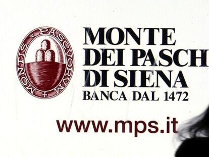 Una mujer pasa delante de un cartel de la entidad italiana Monte dei Paschi.