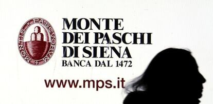 Una mujer pasa delante de un cartel de la entidad italiana Monte dei Paschi.