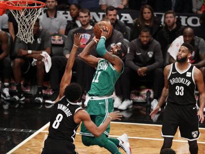 Kyrie Irving, con la m&aacute;scara, lanza ante Dinwiddie.