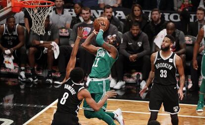 Kyrie Irving, con la m&aacute;scara, lanza ante Dinwiddie.