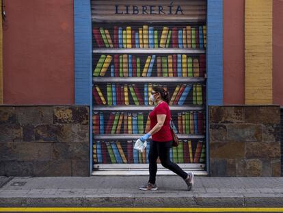 Una dona passa per davant d'una llibreria tancada.