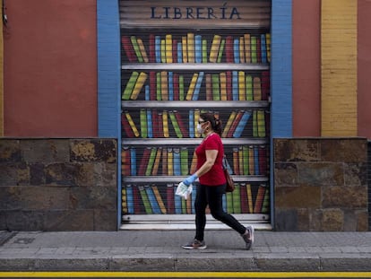 Una dona passa per davant d'una llibreria tancada.