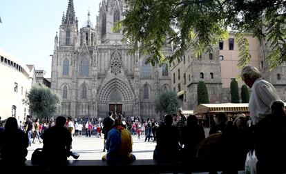 Turistas descansan frente a la catedral de Barcelona.