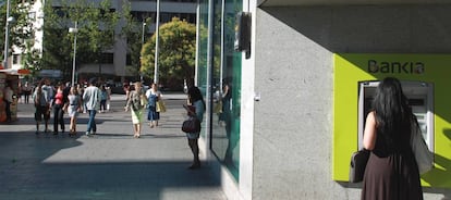 Una persona saca dinero de un cajero de Bankia