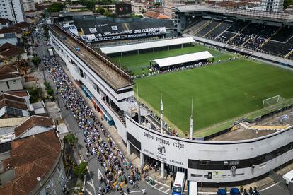 Aficionados hacen cola este lunes  a las puertas del estadio Vila Belmiro en Santos, en Brasil, para despedir a Pelé durante el velatorio de hoy. 
