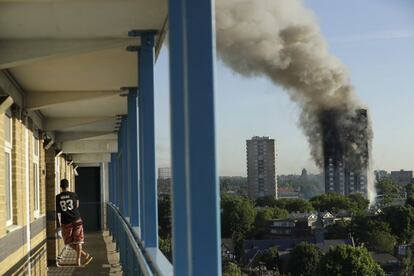 Un vecino observa el incendio en la torre Grenfell de Londres el 14 de junio de 2017 donde murieron al menos 80 personas.