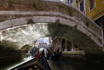 Unas góndolas pasan bajo los puentes de Venecia.
