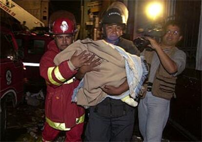 Bomberos rescatan a un bebé en el incendio de Lima.