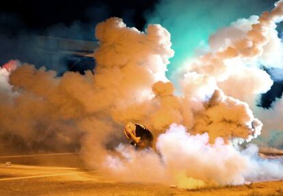 Un manifestante se protege del humo lanzado por la policia el 13 de agosto.