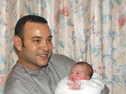 El rey Mohamed VI sostiene en brazos a su hijo recién nacido.
/ AFP