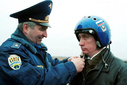El General de las Fuerzas Armadas Alexander Kharchevsky termina de colocar el traje a Vladimir Putin antes de comenzar su vuelo hacia la zona de guerra de chechenia desde Krasnodar, en 2000.