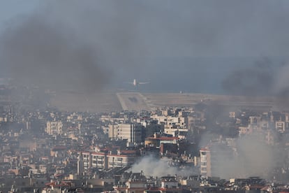 Un avión despega del Aeropuerto Internacional de Beirut mientras el humo se eleva sobre los suburbios del sur de la capital libanesa, este miércoles. 