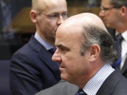 Mario Draghi habla con el responsable de Economía, Luis de Guindos.