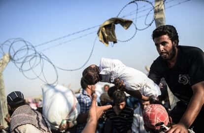 Al mediodía, las autoridades turcas abrieron el cruce, pero sólo pudieron pasar a Turquía cuatro familias antes de que hombres armados impidieran el paso a los demás refugiados.