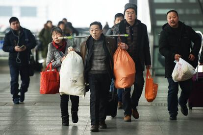 Pasajeros cargan sus bolsas de viaje en la estación de tren de Hangzhou, en la provincia de Zhejiang, el 1 de febrero de 2018.