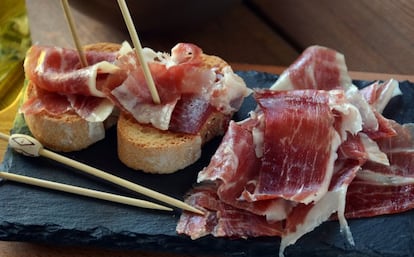 ¿Cuál es la temperatura ideal para que un jamón resulte lo más sabroso posible? “Para que se manifieste toda la calidad del jamón, se tiene que consumir a una temperatura ambiente óptima de 24º, aproximadamente. Cuando es envasado, lo mejor es pasar la bolsa, que en el frigorífico está a 2 o 4 ºC, por el grifo de agua caliente o meterla en un bol para atemperarla hasta que la grasa se ponga transparente. Después, hay que dejarla reposar un minuto antes de abrirla para consumirlo”, explica Arturo Sánchez, productor de derivados del cerdo ibérico en Guijuelo. Josep Pedró, propietario de las charcuterías gourmet La Garriga, coincide, pero apunta que si no hay prisa es mejor todavía dejar que se atempere a temperatura ambiente durante una hora antes de consumirlo. “El problema viene cuando a alguien se le ocurre calentar el plato y se le va la mano”, añade.