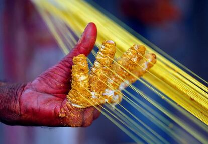 Un trabajador aplica color a varias cuerdas que se utilizarn para volar cometas, en Ahmedabad (India).