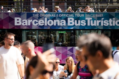 Turistas frente a la Casa Batlló en el Paseo de Gràcia de Barcelona, junto a un bus turístico, este mes de agosto.