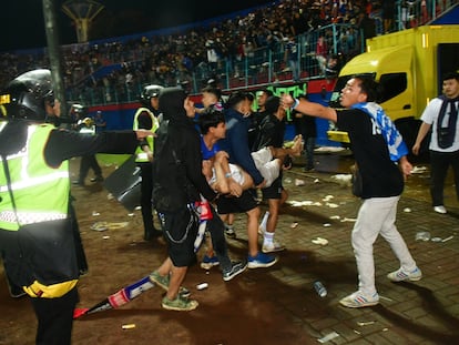 Supporters evacuate a man due to tear gas fired by police during the riot after the football match between Arema vs Persebaya at Kanjuruhan Stadium, Malang, East Java province, Indonesia, October 2, 2022. REUTERS/Stringer NO RESALES. NO ARCHIVES