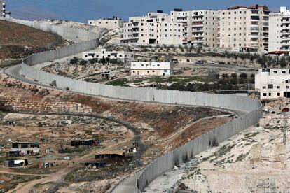 Israel va camino de convertirse en un país cercado por todas partes menos por el mar. Está sellada la frontera norte con Líbano, donde opera el partido-milicia chií Hezbolá y se libró una guerra en 2006. También la de los Altos del Golán, al otro lado de la cual batallan desde 2011 el régimen y lo rebeldes sirios. Como la linde sur con Egipto, vallada primero en 2013 para frenar la inmigración clandestina y ahora por la amenaza de la filial del ISIS en la península de Sinaí. Hasta en la de la pacífica Jordania, país con el que el Estado hebreo firmó un tratado de paz en 1994, se está erigiendo un verja en los 240 kilómetros de frontera común. Pero el muro por antonomasia en Israel es la oficialmente denominada “barrera de separación” de Cisjordania, una sucesión de vallas, rejas y tapias con amplios tramos de altos muros de hormigón jalonados de torres de vigilancia. Su trazado completo está pendiente aún de concluir desde que se iniciara su construcción hace 15 años, en plena Segunda Intifada, el estallido de violencia palestina que sembró el pánico entre la población israelí. Con su serpenteante recorrido —que en algunas zonas como la ciudad de Belén aísla el territorio cisjordano e impide su continuidad— se apodera de más de un 10% del territorio palestino. El Tribunal Internacional de Justicia de La Haya lo declaró ilegal en 2004. En la imagen, mro que separa Jerusalén Este de la ciudad cisjordana de Anata./ J. C. SANZ (Jerusalén)