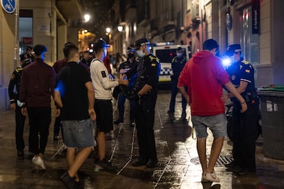 Agentes de la Guàrdia Urbana inspeccionan a unos jóvenes que participaban en un botellón en Sarrià, en 2021.