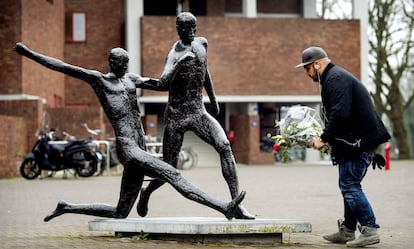 Homem deposita flores diante da estátua de Johan Cruyff, próximo do estádio olímpico em Amsterdã. 