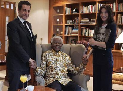 El premio Nobel de la Paz, Nelson Mandela, posa con el presidente francés, Nicolás Sarkozy, y su esposa, Carla Bruni, a ambos lados