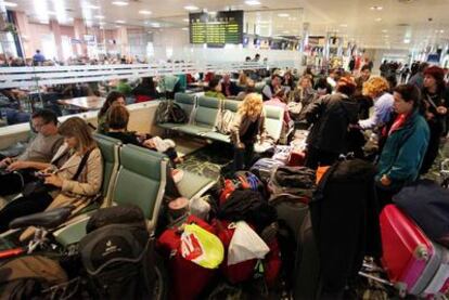 Pasajeros y peregrinos esperan a que el aeropuerto de Lavacolla reinicie las operaciones, ayer al mediodía.