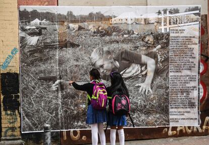 Dos escolares observan un mural de la fotógrafa estadounidense Sara Blesener, en el vecindario de La Candelaria, en Bogotá (Colombia). Dysturb es una red de fotoperiodistas que tienen como objetivo hacer visual la información, a través de la colocación de grandes imágenes en las ciudades.