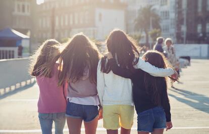 Cuatro adolescentes andan juntas en un bonito día soleado.