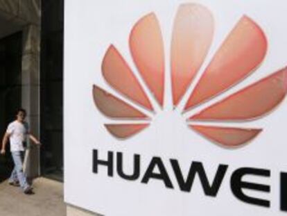 Un hombre pasea junto a un logo de Huawei, en la sede central de la compa&ntilde;&iacute;a.