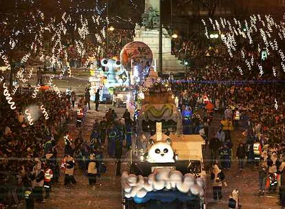 Más de 800 personas repartidas en 21 carrozas participaron ayer en el desfile de la noche de Reyes, que este año tuvo como hilo argumental el cielo y sus criaturas. En la imagen, una parte de la comitiva, rodeada de miles de madrileños, delante de la estatua de Emilio Castelar, en el paseo de la Castellana.