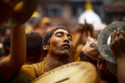 Bailes al ritmo de la música tradicional con los rostros manchados de polvo de color durante la celebración del festival Bisket Jatra en Bhaktapur (Nepal).