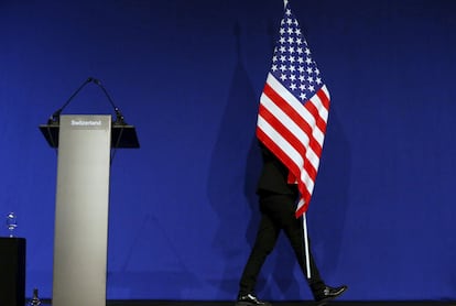 Un funcionario se lleva la bandera de Estados Unidos tras una rueda de prensa del secretario de Estado norteamericano, John Kerry, durante una reunión en Lausana (Suiza), el 2 de abril de 2015.