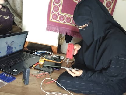 Tahani al-Jaafari trabaja en la reparación de teléfonos móviles en un rincón de su casa, en Taiz (Yemen).