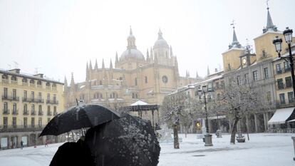 GRAF7184. SEGOVIA, 08/01/2021.- Dos personas caminan por la Plaza Mayor de Segovia durante una intensa nevada, este viernes, jornada marcada por el paso de la borrasca Filomena. EFE/ Pablo Martín