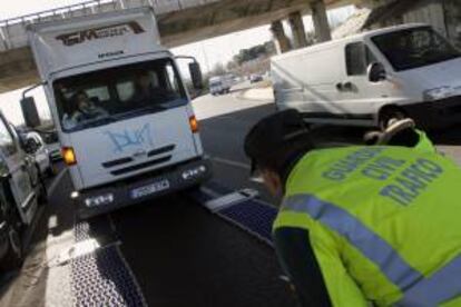 Un agente de la Guardia Civil controla un camión en la autovía A-1 dentro de una campaña especial de la Benemérita sobre vigilancia y control de camiones y furgonetas. EFE/Archivo