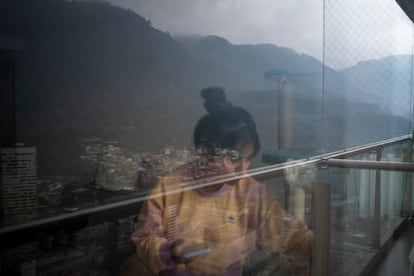 Diana Gómez mira por la ventana de su apartamento.