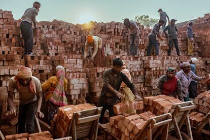 Unos trabajadores descargan los ladrillos cocidos desde el interior del horno en Biratnagar. Aunque las condiciones son muchas veces inhumanas, esta industria emplea a miles de trabajadores no cualificados: más de 300.000 personas lo hacen en condiciones insalubres e inseguras en las fábricas de Nepal.